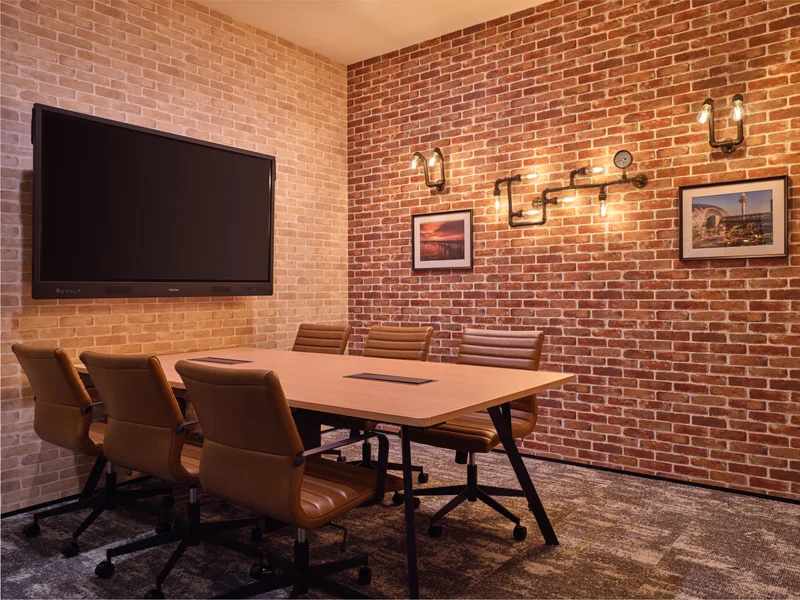 Industrial meeting room with exposed brick, Edison bulbs and leather chairs