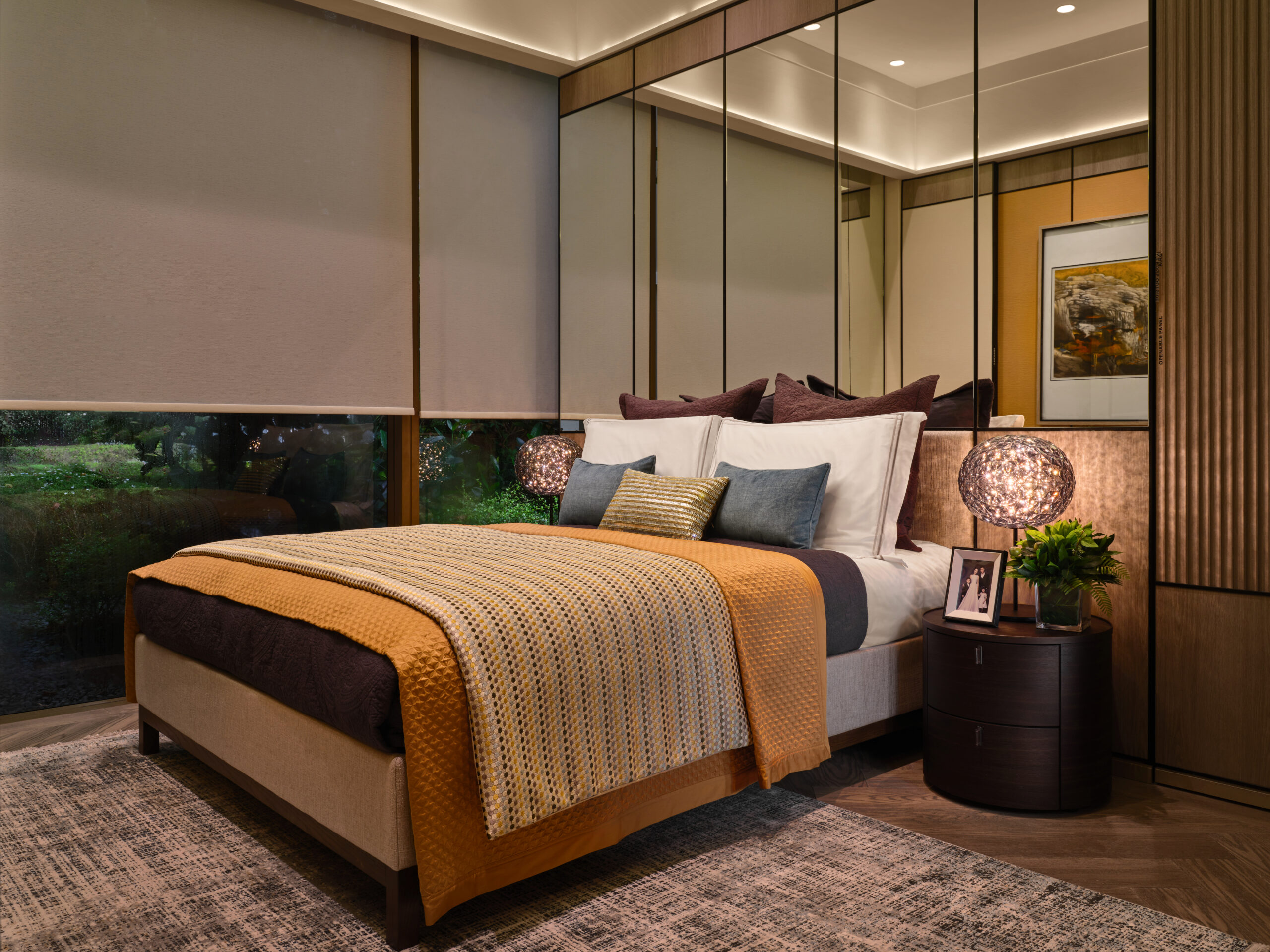 Master bedroom with warm lighting, upholstered bed, and built-in wardrobe in Klimt Cairnhill 2-bedroom showflat