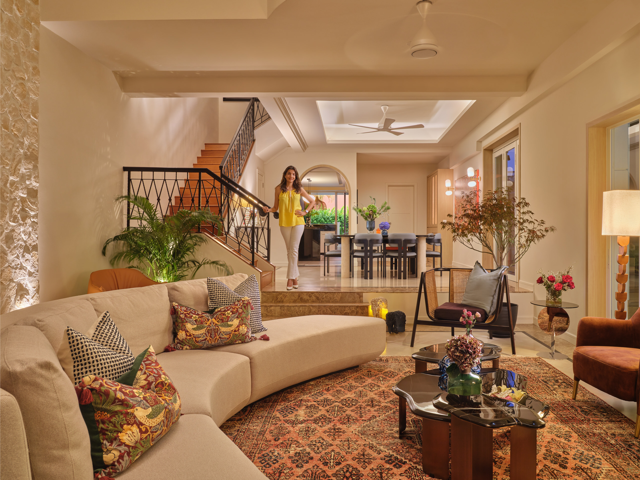 Residential interior design photography of a luxurious living area in East Coast Singapore, with curved seating, warm tones, and intricate detailing featuring Nidhi Jain the designer.