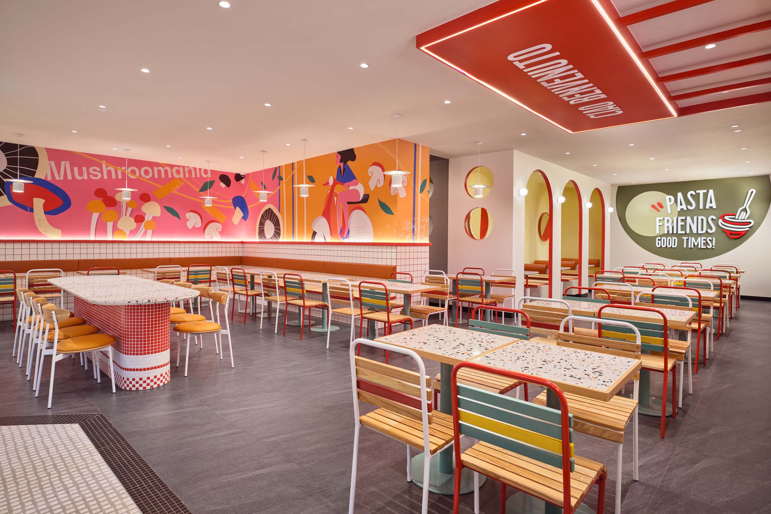 PastaMania Lot One wide view of dining hall showing mural wall, red ceiling feature, and Pasta Friends Good Times signage